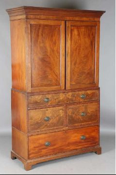 A George III mahogany linen press with line inlaid borders, fitted with two doors and four